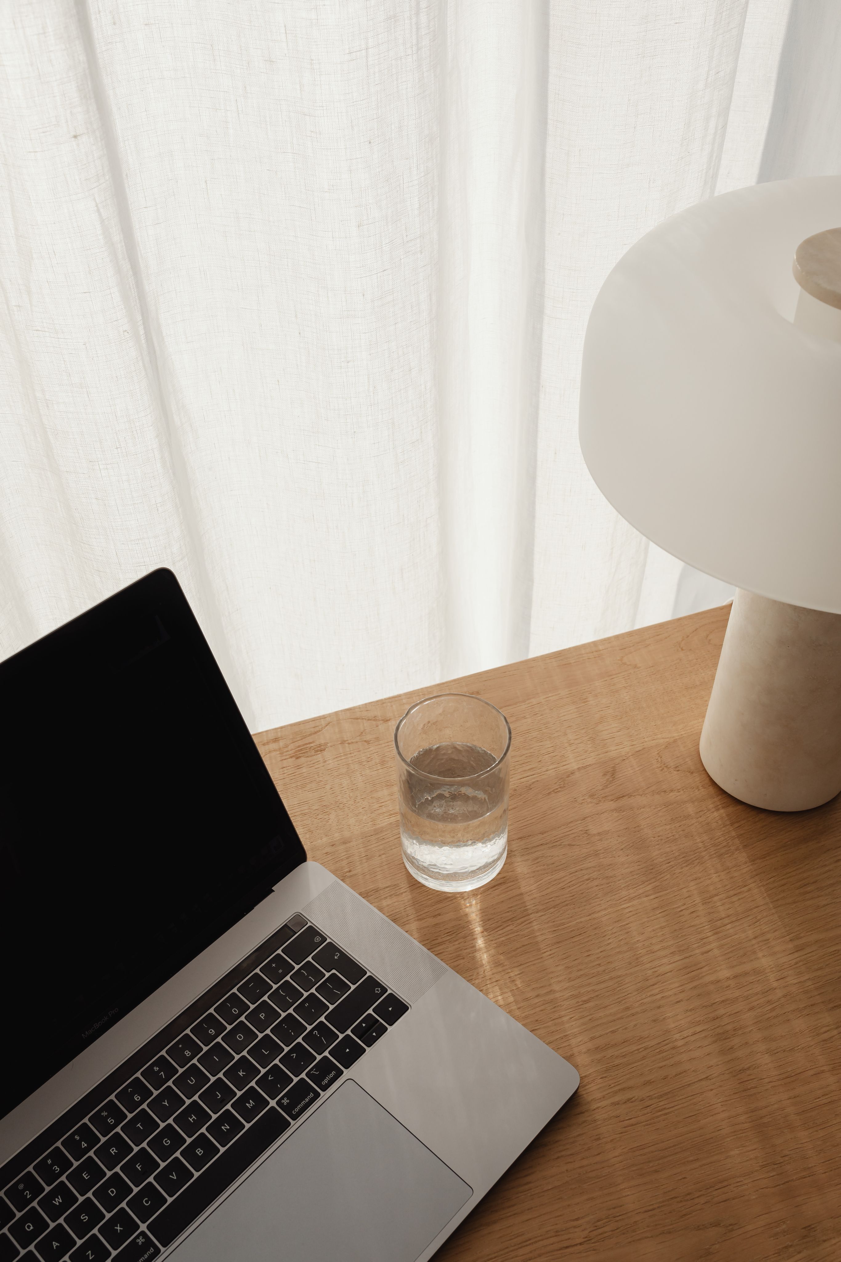Ordinateur portable ouvert à côté d'un verre d'eau