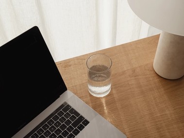 Ordinateur portable ouvert à côté d'un verre d'eau