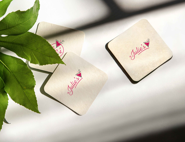 Sous-verres au logo Le Julie's posés près d'une plante