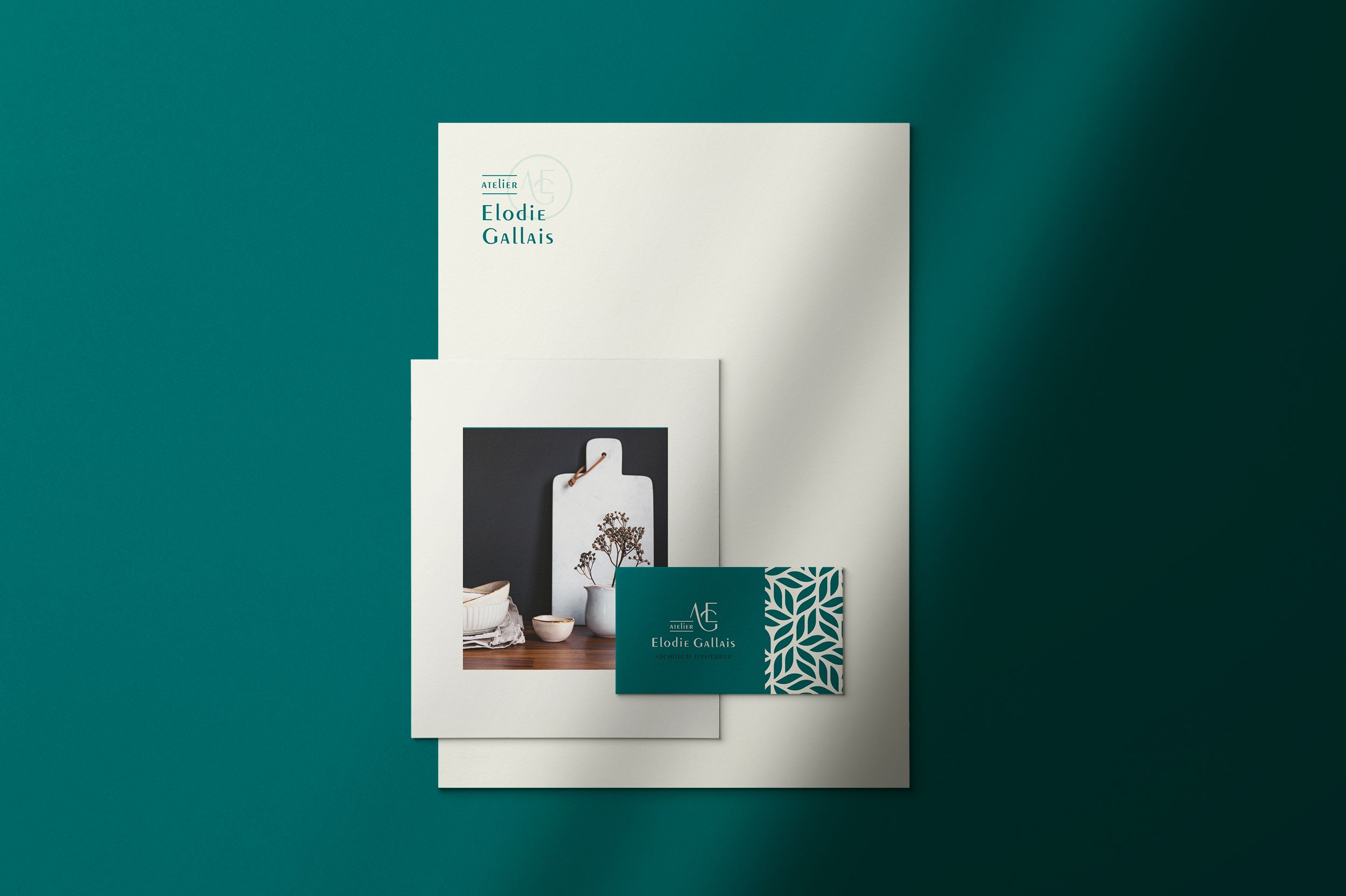 Identité visuelle d'Elodie Gallais avec la carte de visite bleu et son logotype blanc en premier plan puis une image en second plan sur un papier A5 et un papier A4 avec le logotype d'Elodie Gallais en troisième plan.