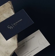 Cartes de visite bleu nuit posées sur une pierre