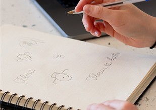 Croquis de pistes de logo dessinés au crayon dans un carnet