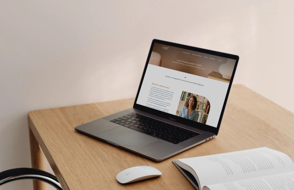 Site internet de CNM Coaching ouvert sur un ordinateur portable, posé sur un bureau en bois