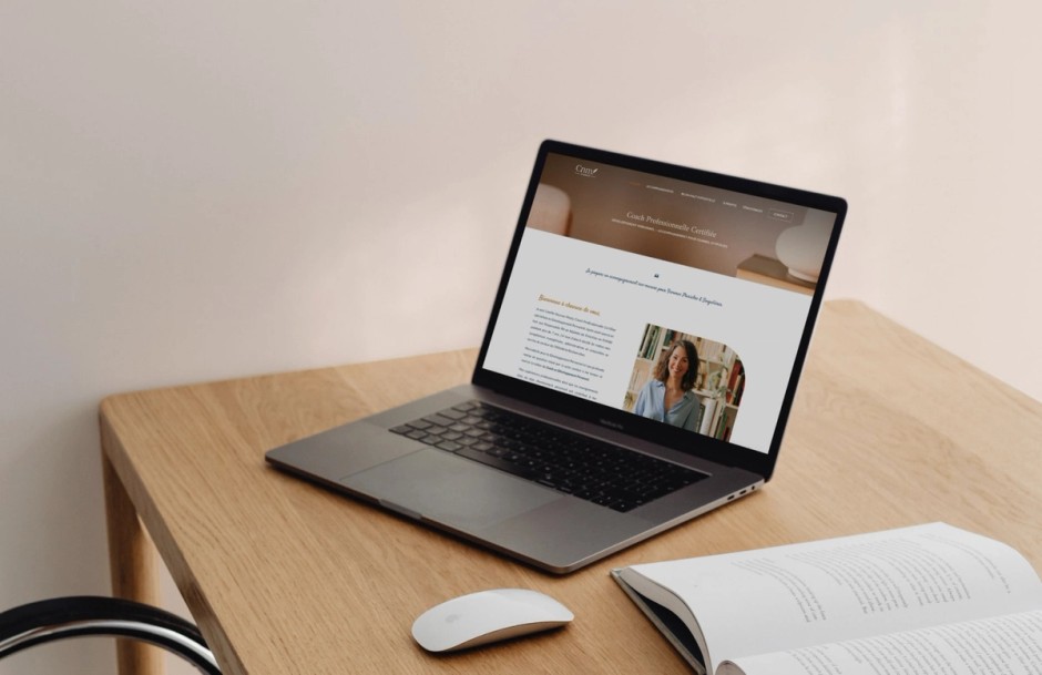 Site internet de CNM Coaching ouvert sur un ordinateur portable, posé sur un bureau en bois