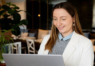 Graphiste souriante échangeant avec un client devant son ordinateur