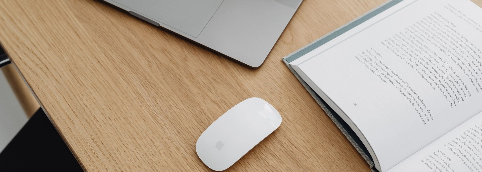 Bureau en bois avec un ordinateur portable, une souris et un livre ouvert