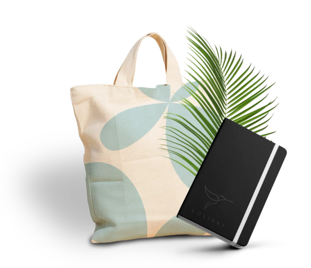 Sac en tissu en arrière-plan et carnet noir portant le logotype gris « Colibri », avec une feuille verte