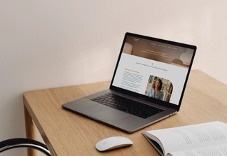 Site internet ouvert sur un ordinateur portable, sur un bureau en bois