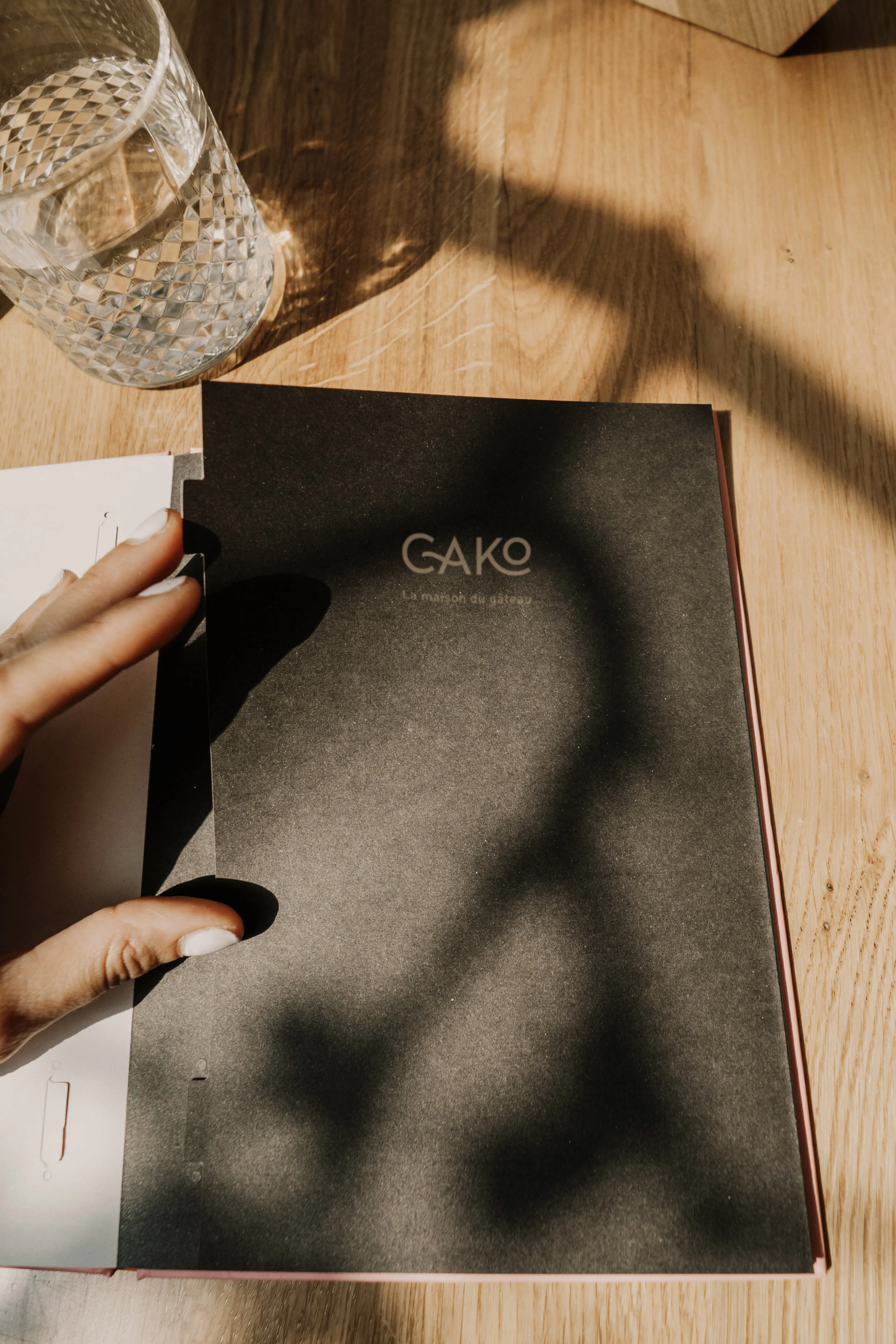 couverture du menu de restaurant noir posé sur une table en bois
