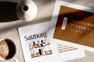 deux feuilles papier sur une table qui présente la typographie Salzburg : les caractères sont écris es uns à la suite des autres