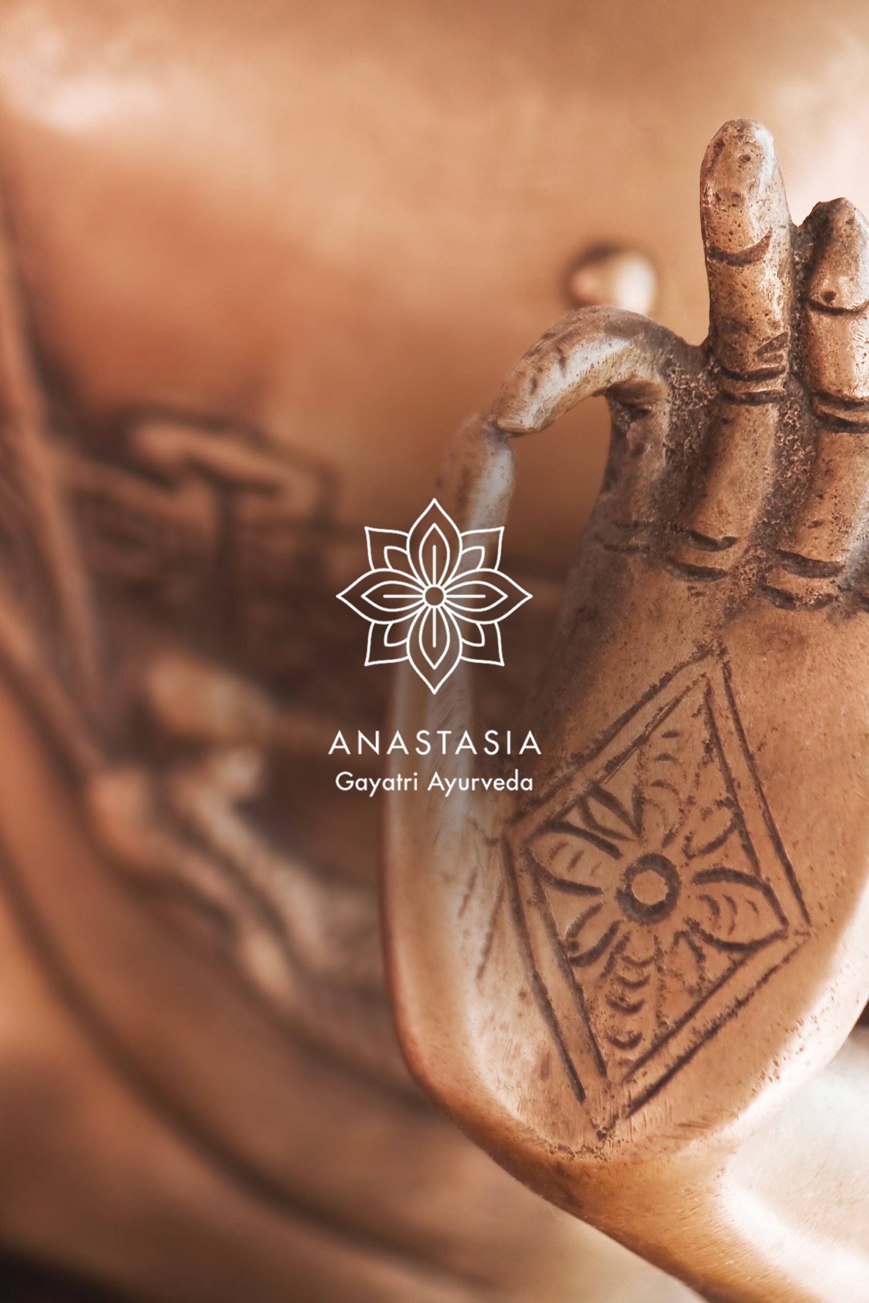 Logo blanc Anastasia Gayatri Ayurveda en arrrière plan on retrouve une photo de bouddha